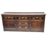 A George III country oak dresser base, circa 1770, moulded top, triple cushion panelled frieze