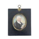 A 19th century portrait miniature, circa 1820, depicting a lawyer in black coat holding a book,