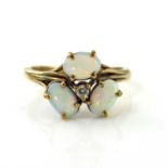 A gold, three stone opal and diamond ring, three opal cabochons around a central diamond, size M 1/