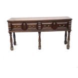 An early 18th Century oak side table, moulded top, twin double cushion paneled frieze drawers with