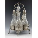 A George III silver reticulated cruet stand and five cut glass bottles,