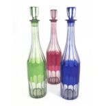 Three Bohemian coloured cased glass liqueur decanters, circa 1880, slender cylinder form, slice