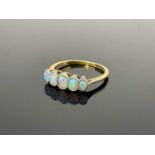 An 18ct gold five stone opal ring, with bezel set graduaed oval cabochon cut stones