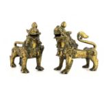 A pair of Chinese bronze lion dogs of shishi, each modelled on four legs, curled tails and