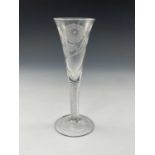 A Jacobite air twist wine glass or flute, circa 1740, the trumpet bowl engraved with a seven petal