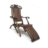 A folding wooden 'steamer' deck chair, early 20th Century, carved top rail, woven rattan seat,