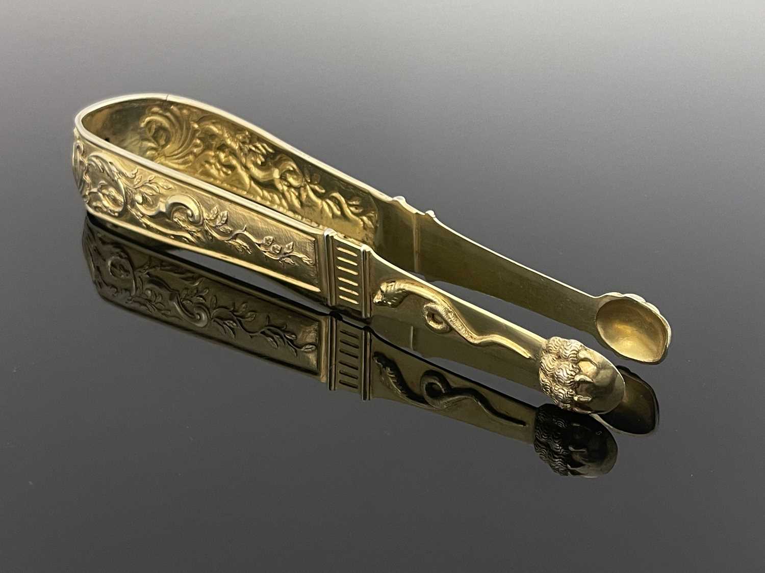 A large pair of Continental silver gilt sugar tongs, circa 1790, cast and chased in relief with