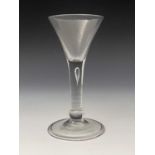 A basal knopped wine glass, circa 1740, the trumpet bowl on a plain stem with internal tear drop air