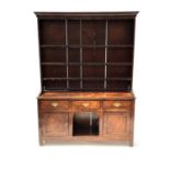 A George III country oak dresser, circa 1780, plain moulded cornice, panelled back plate rack,