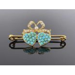 A Victorian gold, turquoise and split pearl brooch, in the form of two hearts united by a bow, on