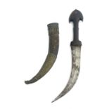 An Arabic jambiya, double edged blade, rhinoceros horn handle, housed in leather scabbard with metal