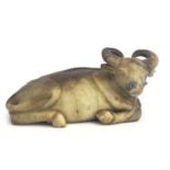 A Chinese jade style carved figure of an ox, modelled reclining, russet horns and veins, 27cm long