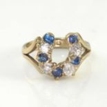 A 9ct gold horseshoe ring, nine diamonds and sapphires, size O