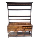 A George III country oak dresser. circa 1770, open plate rack, a bank of spice drawers below, the