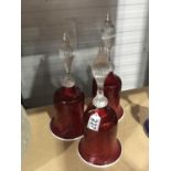 Three Victorian Cranberry glass bells, with wrythen clear glass handles (3)