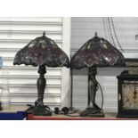 A pair of Tiffany style table lamps, each with lobed lapett leaded glass shades, on cast metal