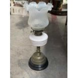 A Victorian oil lamp, opaque white glass reservoir on brass knopped stem and reticulated domed