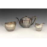 An Edwardian silver three-piece tea set, comprising teapot, sugar bowl and cream jug, each decorated