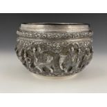A twentieth-century Oriental silver-coloured metal bowl, the body decorated in high relief with