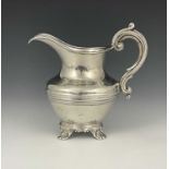 A Victorian silver cream jug, of squat baluster form with central ribbed banding, atop a cast and