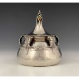 An Edwardian Arts and Crafts silver inkwell, of squat ovoid form, the spot-hammered body supported