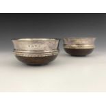 A pair of George VI Arts and Crafts style silver mounted mazer bowls, each with turned wooden bases,