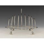 A George III silver nine-bar toast rack, the frame of oval form with wire divisions, atop four