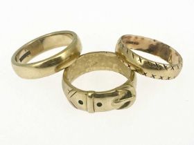 Three 9 carat gold rings and wedding bands, including a buckled belt, sizes U and V, 20.12g (3)