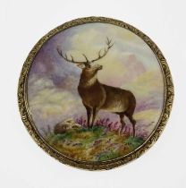 A gold mounted porcelain plaque brooch, circular form, painted with a mirror image of Monarch of the