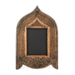 An Arts and Crafts copper photo frame, Persian arch form, repousse embossed with rope border and