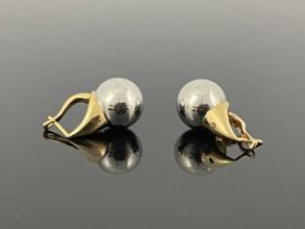 A matched pair of 14 carat gold bi colour earrings, white gold spheres on yellow claws, one set with