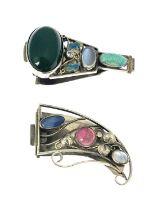 Two white metal Arts & Crafts style clips, each enamelled and inset with semi-precious stones,