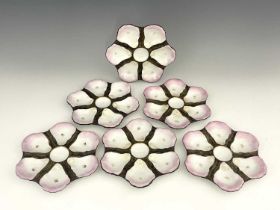 Ginori, Italy, a set of six oyster plates, brown and pink glazed with gilt-framed central wells,