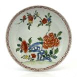A Chinese famille rose dish or large saucer, 18th century, painted and enamelled with peony and root