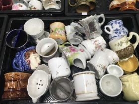 A collection of Continental and English pottery and porcelain shaving mugs, including a Welsh