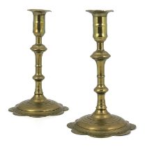 A pair of George II seamed brass petal based candlesticks, circa 1735, the multi knopped baluster