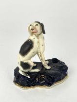 A Rockingham-type model of a black and white sporting dog, seated wearing a gilt collar and chain