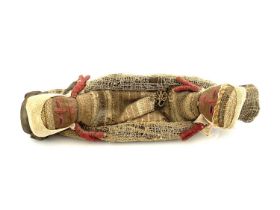 A Peruvian Chancay textile burial doll group, two figures lying in a boat, 23cm long