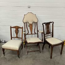 An Edwardian mahogany and marquetry inlaid folding chair, together with a similar nursing chair, and