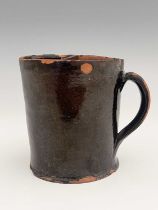 An American redware shaving mug, circa 1820, cylindrical form, with bisected aperture, and loop