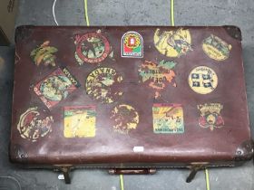 A leatherette travel trunk with various labels, containing binoculars including Carl Zeiss etc.