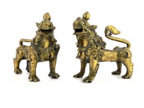 A pair of Chinese bronze lion dogs of shishi, each modelled on four legs, curled tails and