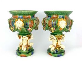 A pair of majolica glazed jardinieres, lion mask and garlands to the frieze, integral triple figural
