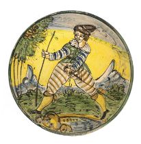 A Montelupo dish, decorated in a typical palette depicting a male figure with sabre and walking