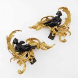 A pair of bronze and gilt metal wall brackets, each with seated figure of a child, one with a