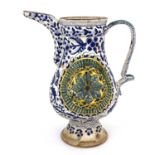 A Turkish Ottoman pottery ewer, footed baluster form, relief moulded floral roundels within blue and