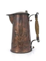 An Arts and Crafts copper lidded jug, repousse embossed with fleur de lys motifs to each side,