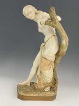 A Royal Worcester figure 'The Bather', circa 1903 modelled as a semi robed maiden afore a tree stump