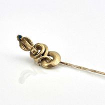 A 9ct gold stick or tie pin with coiled cobra finial, set sapphire, hallmarked, 3.7g