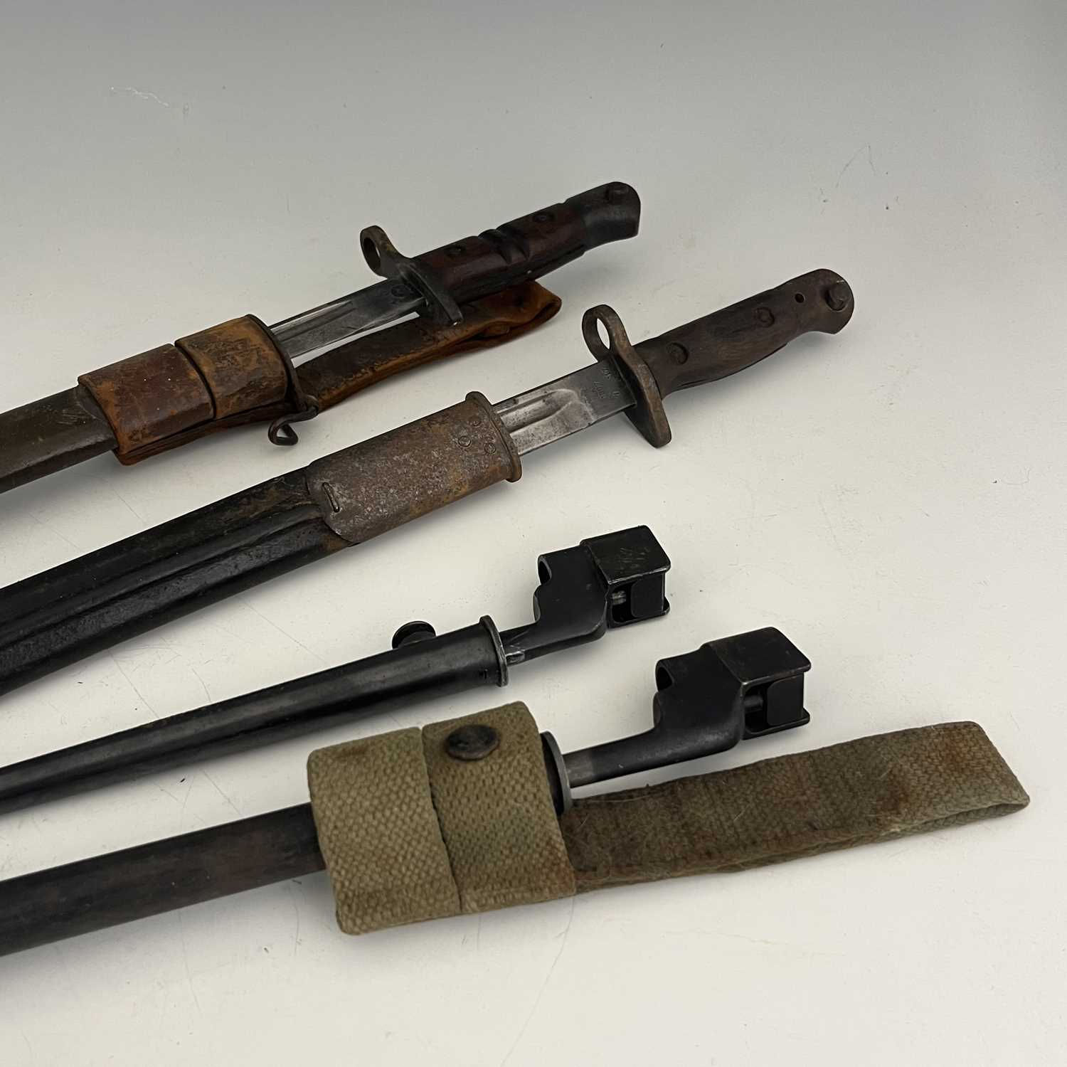Four British bayonets, including a 1907 pattern SMLE sword bayonet by Remington, two piece wooden